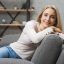 portrait-young-smiling-woman-leaning-sofa-home-scaled.jpg